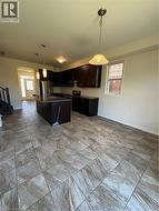 Kitchen featuring pendant lighting, refrigerator, electric range, and healthy amount of natural light - 