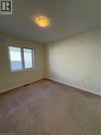 Empty room featuring baseboards and carpet - 