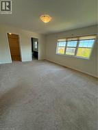 Unfurnished bedroom with a spacious closet, carpet flooring, and ensuite bath - 