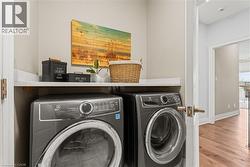 Laundry room featuring wood finished floors and washer and dryer - 