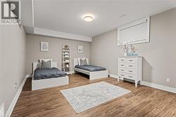 Bedroom featuring wood finished floors and baseboards - 