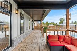 Wooden terrace with an outdoor living space, a fenced backyard, and a gazebo - 