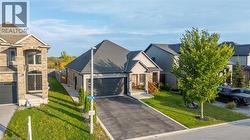 View of front of property with stone siding, driveway, and a front yard - 