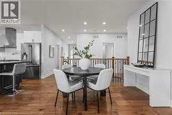 Dining room with dark wood-style flooring and recessed lighting - 