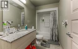 Full bathroom featuring toilet, shower / bath combo, vanity, and tile patterned floors - 