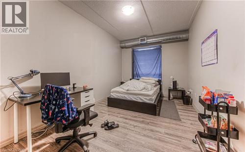 Bedroom featuring wood-type flooring and a textured ceiling - 8 Hickory Street W Unit# 401, Waterloo, ON - Indoor