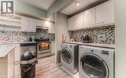 Laundry room with washer and clothes dryer, sink, and light hardwood / wood-style flooring - 