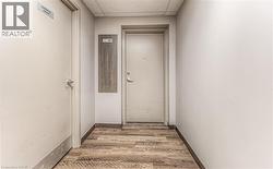Corridor with hardwood / wood-style floors and a drop ceiling - 