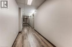 Hall featuring wood-type flooring and a paneled ceiling - 