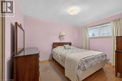 Primary bedroom features hardwood flooring. - 