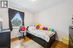 Bedroom featuring hardwood / wood-style flooring and baseboards - 