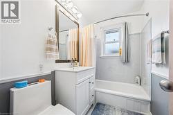 Bathroom featuring shower / bath combo with shower curtain and vanity - 
