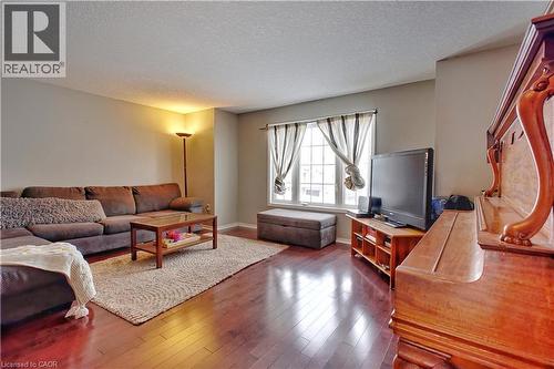 Living area featuring a textured ceiling and dark wood-style floors - 206 Westmeadow Drive, Kitchener, ON - Indoor Photo Showing Living Room