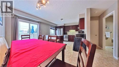 Dining area with a textured ceiling and light tile patterned floors - 206 Westmeadow Drive, Kitchener, ON - Indoor Photo Showing Dining Room