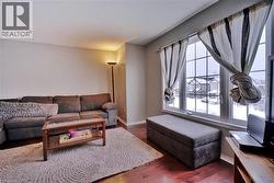 Living area with hardwood / wood-style flooring and baseboards - 