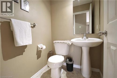 Half bathroom featuring toilet and light tile patterned floors - 206 Westmeadow Drive, Kitchener, ON - Indoor Photo Showing Bathroom