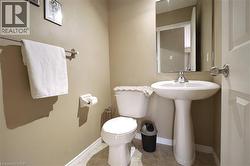 Half bathroom featuring toilet and light tile patterned floors - 