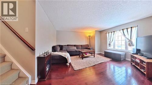 Living room featuring stairway, dark wood-style floors, and a textured ceiling - 206 Westmeadow Drive, Kitchener, ON - Indoor