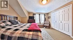 Carpeted bedroom with a closet and a textured ceiling - 