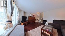 Living room with stairway, a textured ceiling, and wood finished floors - 