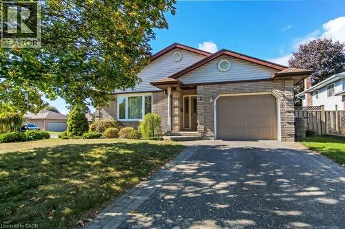 View of front of home with brick siding, driveway, an attached garage, and a front lawn - 2 Falls Crescent, Simcoe, ON - Outdoor With Facade