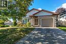 View of front of home with brick siding, driveway, an attached garage, and a front lawn - 2 Falls Crescent, Simcoe, ON  - Outdoor With Facade 
