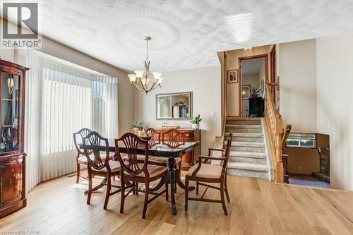 Dining space featuring wood finished floors, stairway, and a chandelier - 2 Falls Crescent, Simcoe, ON - Indoor Photo Showing Dining Room