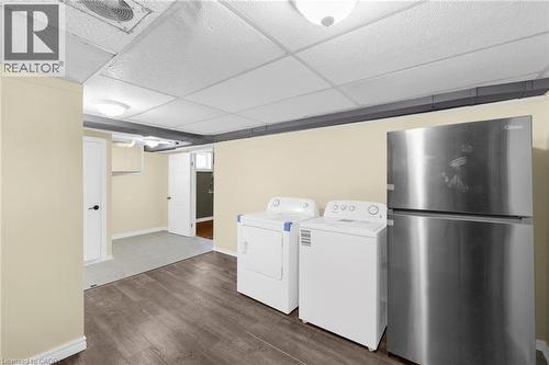 Laundry room featuring dark wood finished floors, a drop ceiling, and washing machine and dryer - 368 Upper Kenilworth Avenue, Hamilton, ON - Indoor Photo Showing Laundry Room