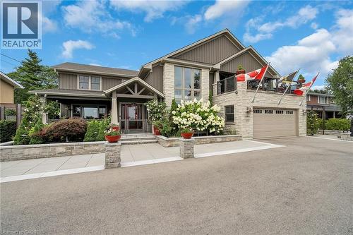 Craftsman-style house featuring driveway, stone siding, a garage, and covered porch - 404 Mountain Brow Boulevard E, Hamilton, ON - Outdoor With Facade