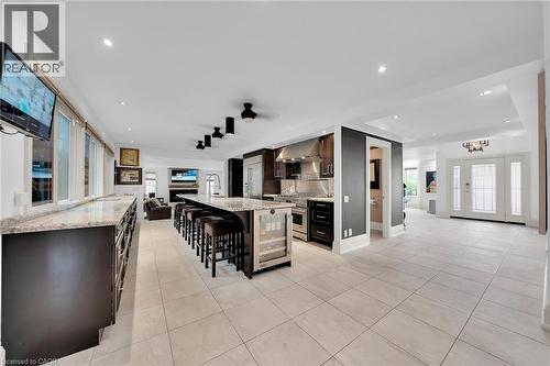 Bar with light tile patterned flooring, light stone countertops, dark brown cabinets, a fireplace, and recessed lighting - 404 Mountain Brow Boulevard E, Hamilton, ON - Indoor Photo Showing Other Room