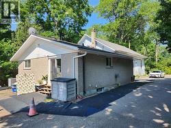 View of side of home featuring brick siding and a chimney - 