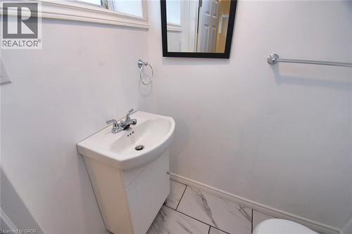 Bathroom featuring vanity and marble look tiles - 215 Walter Avenue S, Hamilton, ON - Indoor Photo Showing Bathroom