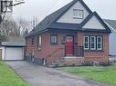 Brick-front exterior with black-trimmed windows and a vibrant red entry door - 215 Walter Avenue S, Hamilton, ON  - Outdoor 