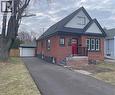 Bungalow-style home with brick siding, an outbuilding, a detached garage, and a shingled roof - 215 Walter Avenue S, Hamilton, ON  - Outdoor 