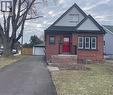 View of front facade featuring brick siding, a front yard, a detached garage, and an outdoor structure - 215 Walter Avenue S, Hamilton, ON  - Outdoor 