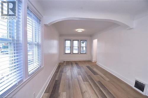 Empty room with wood finished floors and arched walkways - 215 Walter Avenue S, Hamilton, ON - Indoor Photo Showing Other Room