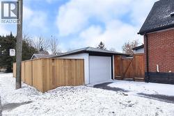Snow covered garage featuring a gate - 