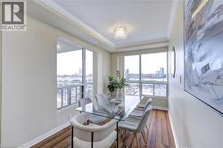Dining room featuring a view of city, crown molding, wood finished floors, and a chandelier - 
