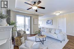 Living area with crown molding, ceiling fan, wood finished floors, and a chandelier - 