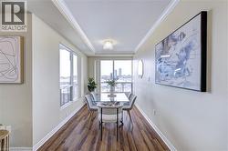 Dining space with dark wood finished floors and ornamental molding - 