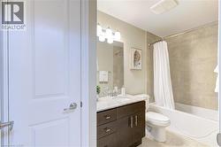 Bathroom with vanity, shower / bathtub combination with curtain, and light tile patterned floors - 