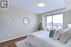 Bedroom with baseboards and dark wood finished floors - 