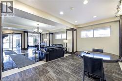 Living room with a chandelier, a raised ceiling, ornamental molding, and recessed lighting - 