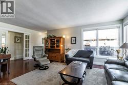 Living area featuring a textured ceiling, healthy amount of natural light, and dark wood-style flooring - 