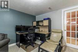 Office space with a textured ceiling and light carpet - 