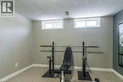 Workout area with a textured ceiling and light colored carpet - 