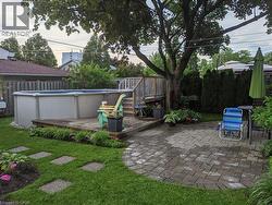 View of yard with a wooden deck, a covered pool, and a patio area - 