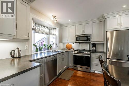 Kitchen featuring stainless steel appliances, dark countertops, dark wood finished floors, gray cabinets, and recessed lighting - 22 Redwing Road, Hamilton, ON - Indoor Photo Showing Kitchen With Upgraded Kitchen