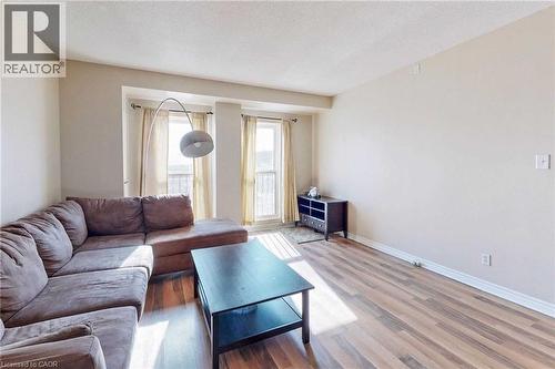 Living room featuring hardwood / wood-style floors and a textured ceiling - 135 James Street Unit# 608, Hamilton, ON - Indoor Photo Showing Living Room