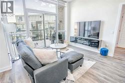 Living room with floor to ceiling windows, healthy amount of natural light, and light wood-type flooring - 